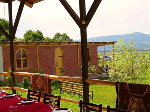 a table with a red table cloth and a building at Villa Rbona in Khashuri
