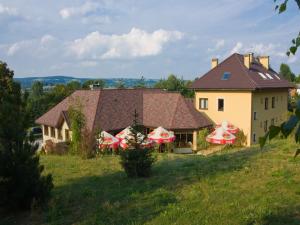 dom na wzgórzu z parasolami na polu w obiekcie Hotel Kochanów w Kochanowie
