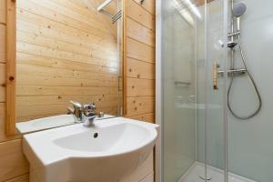 a bathroom with a sink and a shower at Biała Wioska 2 in Ustronie Morskie