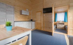 a kitchen in a wooden cabin with a table at Biała Wioska 2 in Ustronie Morskie