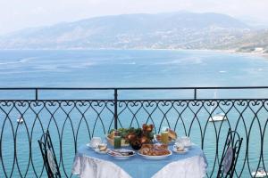 パリヌーロにあるHotel Palinuroの海を望むバルコニーの上にテーブルと食べ物