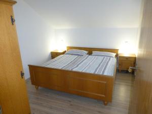 ein Schlafzimmer mit einem Bett und zwei Nachttischen in der Unterkunft Ferienwohnung Bösch in Taching am See