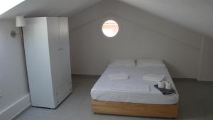 a white bedroom with a bed with a window at Villa Giotis in Skala Sotiros