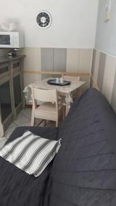 a room with a table and a bed and a table and chair at Petite maison proche océan Boulevard de l'amelie in Soulac-sur-Mer