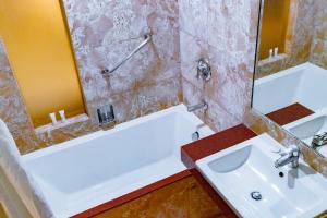 
a bathroom with a tub, sink, and mirror at Crown Regency Beach Resort in Boracay
