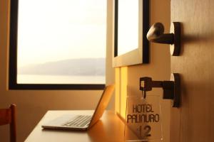 ein Schild an einer Tür mit einem Laptop auf dem Schreibtisch in der Unterkunft Hotel Palinuro in Palinuro