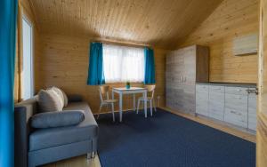 a living room with a couch and a table at Biała Wioska 2 in Ustronie Morskie