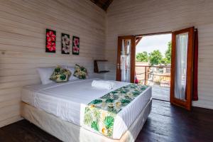 a bedroom with a bed and a sliding glass door at Voodoo Gili in Gili Trawangan