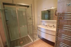 y baño con ducha acristalada y lavamanos. en Croisette Martinez 1 Bedroom 241, en Cannes