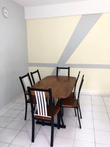 a wooden table and chairs in a room at PD Perdana Homestay Pool side in Port Dickson