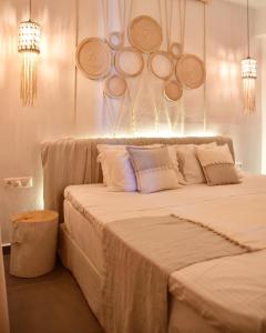 a bedroom with a large bed with hats on the wall at Angelos Design Suites in Patitiri