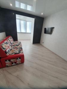 ein Wohnzimmer mit einem roten Sofa und einem Flachbild-TV in der Unterkunft вулиця Дмитра Іващенка Апартаменти in Luzk