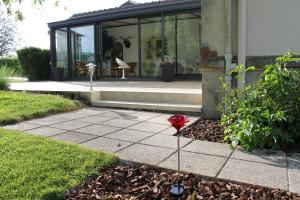 une maison avec un oiseau rouge sur le trottoir dans l'établissement La maison de TOINETTE, à Jonchery-sur-Suippe