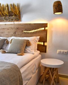 a bedroom with a bed with a wooden headboard at Angelos Design Suites in Patitiri