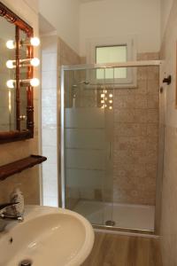 a bathroom with a glass shower and a sink at La Lanterna delle Fate in Otranto