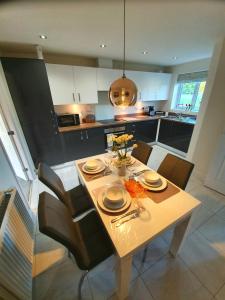 uma cozinha com uma mesa com cadeiras e uma sala de jantar em Meadow View, luxury home in heart of England em Shirebrook