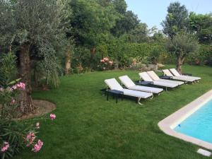 a row of lounge chairs sitting next to a swimming pool at Villa Louise-Rose in Villeneuve-Loubet