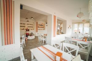 a dining room with white tables and chairs at Kvasova Voda in Polyana