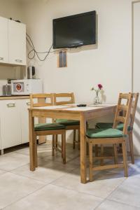a dining room table with chairs and a television on the wall at Harmony Hostel in Zator