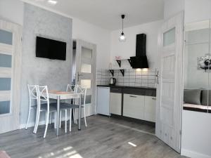 a kitchen with a table and chairs in a room at Domki pod Katalpami in Mikołajki