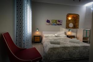 ピッツォにあるVilla Primaluceのベッドルーム1室(ベッド1台、赤い椅子付)