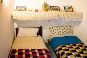 Pokój z dwoma łóżkami i półką z obrazami w obiekcie Moroccan Dream Hostel w Fezie