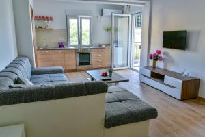 a living room with a couch and a kitchen at Apartmani Marina Kopitovic in Petrovac na Moru