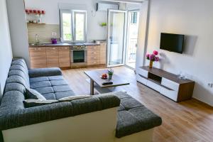 a living room with a couch and a table at Apartmani Marina Kopitovic in Petrovac na Moru