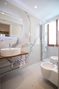 La salle de bains blanche est pourvue d'un lavabo et de toilettes. dans l'établissement Feel Good, à Rimini
