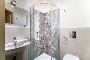 a bathroom with a shower, toilet, and sink at Vela Rooms in Cagliari