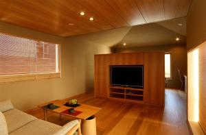 ein Wohnzimmer mit einem Sofa und einem TV in der Unterkunft Maru Izumiyacho in Kyoto