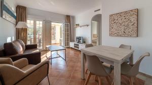 a living room with a table and a couch at Apartamentos Costaluz Las Dunas in Isla Canela