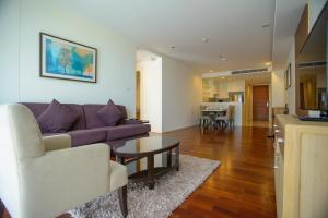 バンコクにあるGM Serviced Apartment (SHA Certified)の紫色のソファとテーブルのあるリビングルーム