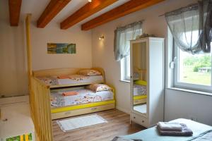 2 łóżka piętrowe w pokoju z oknem w obiekcie HišaŠmihelka w mieście Kobarid