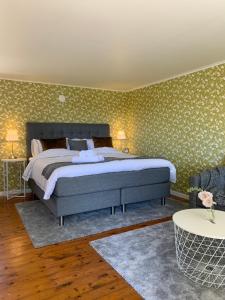 a bedroom with a large bed and green wallpaper at Gannarve Gård in Klintehamn