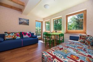 a room with a bed and a couch and a table at Vila PRI Rouzes in Palanga