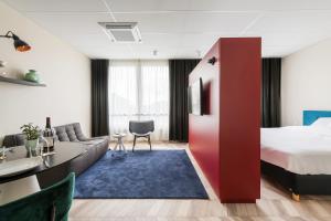 um quarto de hotel com uma cama e um sofá em ROXI The Urban Residence Brussels em Bruxelas