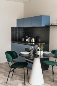 a kitchen with green chairs and a table with wine glasses at ROXI The Urban Residence Brussels in Brussels +33 photos