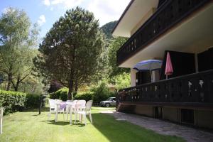 a table and chairs on a lawn next to a house at Residence Ledro in Ledro