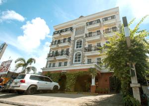 a white car parked in front of a building at Hotel Emilia in Davao City