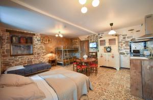 a bedroom with two beds and a kitchen with a table at Domaine de la Palombe in Villiers-Fossard