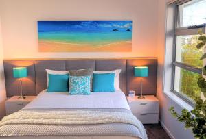 a bedroom with a bed, a lamp, and a window at Ulverstone River Edge HolidayApartments in Ulverstone