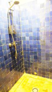
a bathroom with a shower stall with a blue tile floor at Ryad 91 in Casablanca
