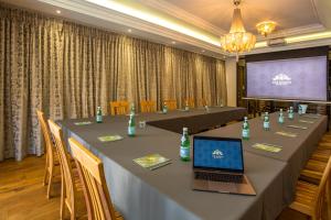 a conference room with a table with a laptop on it at The Giglio Boutique Hotel in Johannesburg