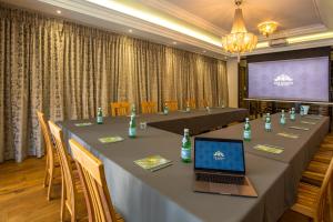 uma sala de conferências com uma mesa com um computador portátil em The Giglio Boutique Hotel em Joanesburgo