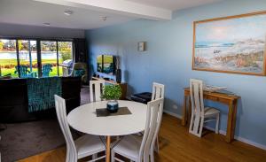 a dining room with a white table and chairs at Ulverstone River Edge HolidayApartments in Ulverstone