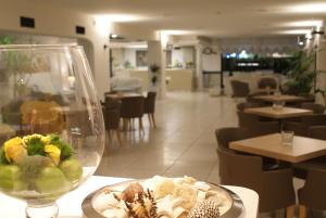 einen Teller Essen auf einem Tisch in einem Restaurant in der Unterkunft Hotel Granada in Milano Marittima