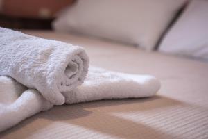 a pile of white towels on a bed at Depis Luxury Suites in Naxos Chora