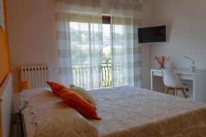 een slaapkamer met een bed met kussens en een raam bij Flower's Home in Sorrento