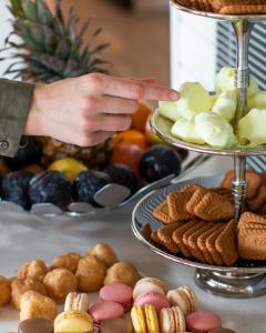 a person pointing at a display of cookies and other desserts at Kultaranta Resort in Naantali